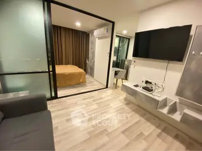Modern apartment interior with open living room and bedroom, featuring sleek design and wooden flooring.