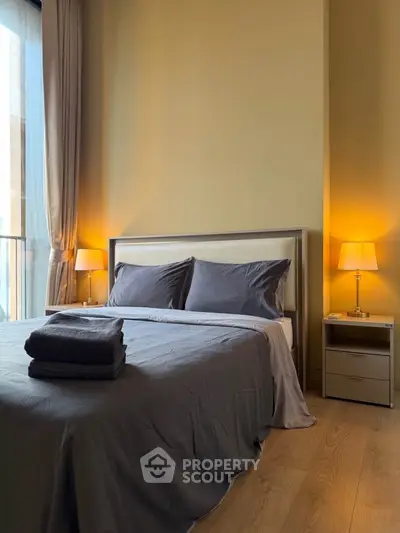 Cozy bedroom with modern decor and warm lighting, featuring a comfortable bed and stylish bedside lamps.