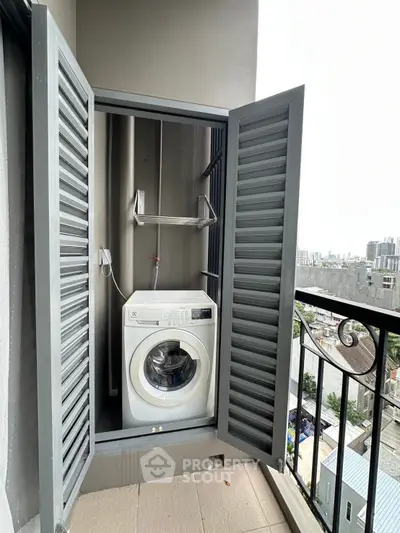 Compact balcony with washing machine and city view, ideal for urban living.