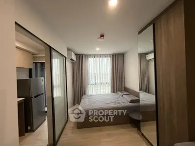 Modern bedroom with sleek design, featuring a large bed, mirrored wardrobe, and natural light from large windows.