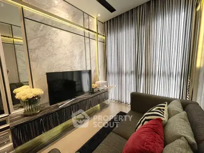 Luxurious living room with modern decor and large TV, featuring elegant curtains and stylish furniture.