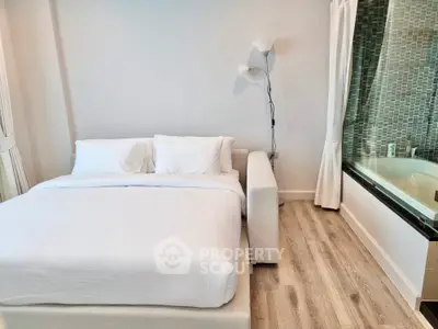 Modern bedroom with a large comfortable bed, sleek design, hardwood floors, and an inviting jacuzzi tub for relaxation.