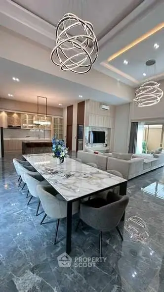 Luxurious open-plan living and dining area with modern lighting and marble flooring.