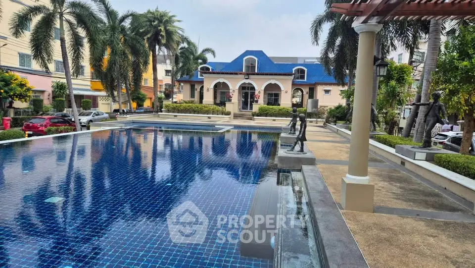 Luxurious residential pool area with elegant architecture and lush palm trees, perfect for relaxation and leisure.