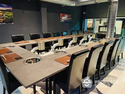 Modern dining area with unique table design and sleek black chairs in a stylish restaurant setting.