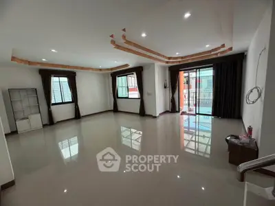 Spacious living room with large windows and balcony access, perfect for modern living.
