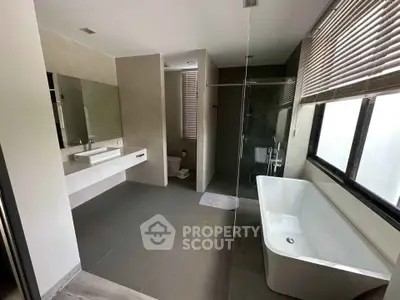 Spacious modern bathroom with bathtub and large windows