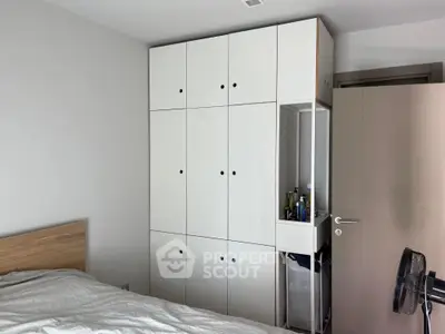 Modern bedroom with built-in white storage cabinets and cozy bed setup