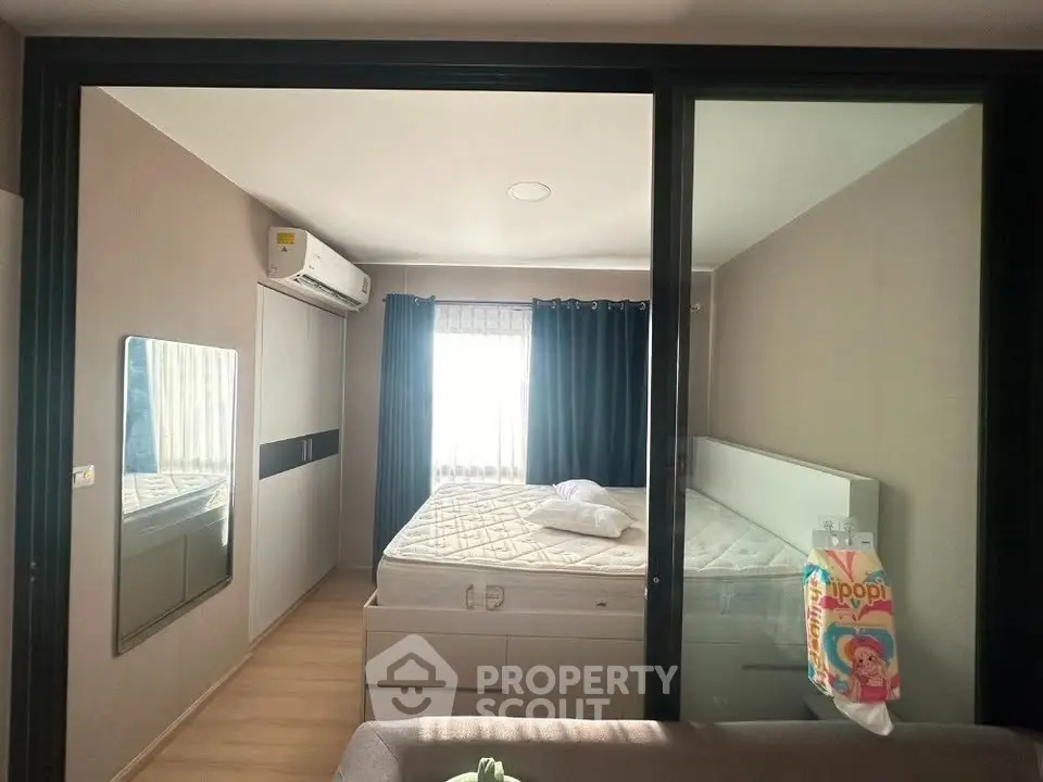 Cozy bedroom with modern design, featuring a large bed, mirrored wardrobe, and natural light from a window.