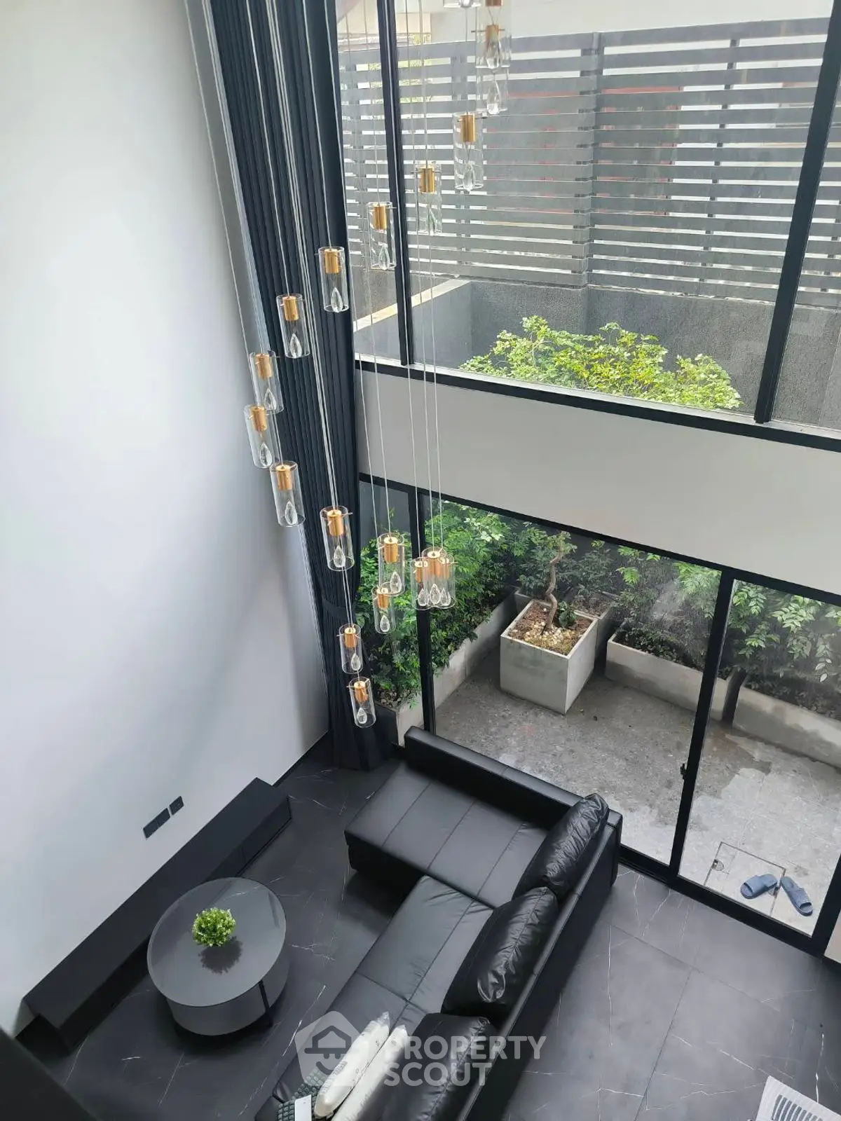 Stunning modern living room with high ceilings and large windows overlooking a private garden.