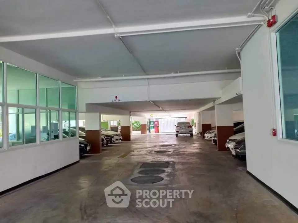 Spacious covered parking area with multiple car spaces in modern building.