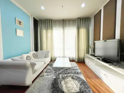 Stylish living room with modern decor, cozy sofa, and large TV, perfect for relaxation and entertainment.