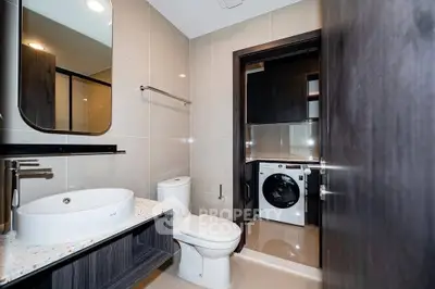 Modern bathroom with integrated laundry area and sleek design.