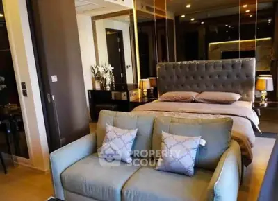 Luxurious bedroom with elegant decor and plush seating in modern apartment.