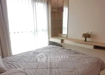 Cozy bedroom with natural light and elegant decor, featuring a stylish vanity and plush bedding.