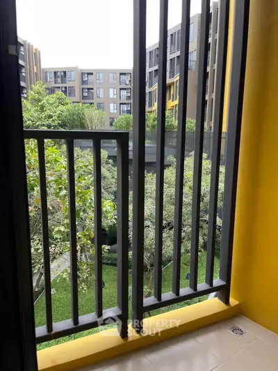 Modern apartment balcony with garden view and sleek railing design.