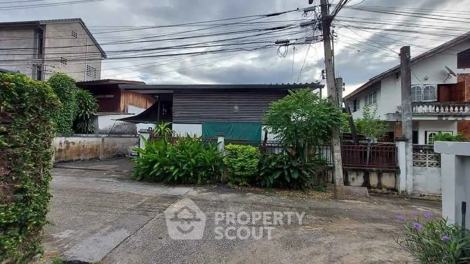 Charming residential street view with lush greenery and modern house exterior.