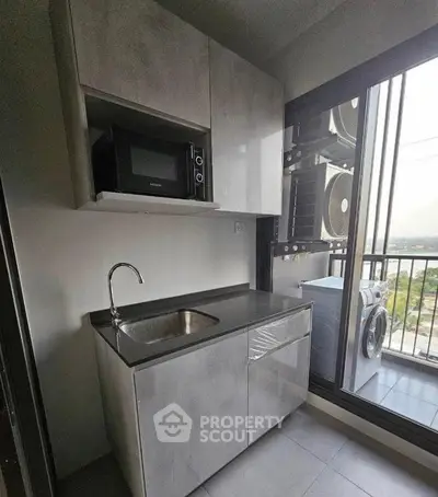 Modern compact kitchen with balcony view and washing machine