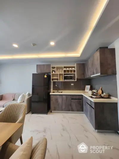 Modern kitchen with sleek cabinetry and integrated appliances in open-plan living space.