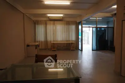 Spacious open-plan living area with large windows and modern furnishings.