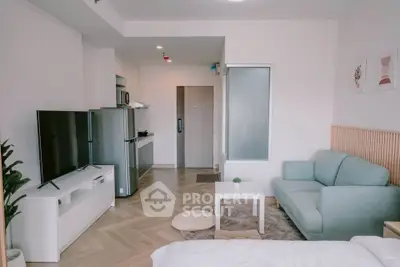 Modern open-plan living room with stylish furniture and sleek kitchen in a cozy apartment.
