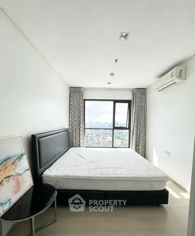 Bright bedroom with large window offering city view, modern bed, and air conditioning.