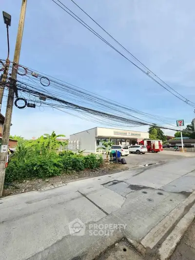 Street view of commercial building with parking area and clear sky