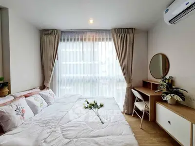 Cozy bedroom with natural light, elegant decor, and modern furnishings for a serene living experience.
