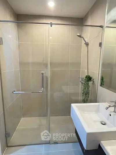 Modern bathroom with glass shower enclosure and sleek sink design