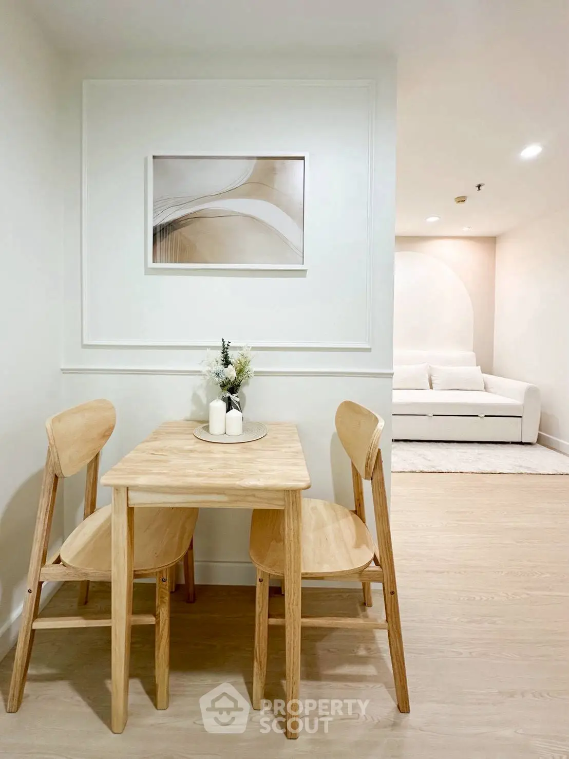 Cozy dining area with wooden table and chairs, modern art, and soft lighting.