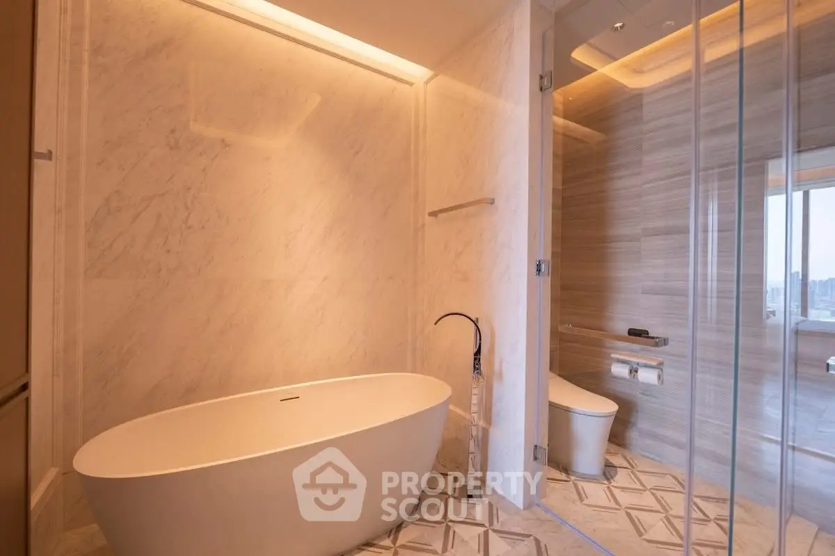 Luxurious modern bathroom with elegant freestanding bathtub and glass-enclosed shower.