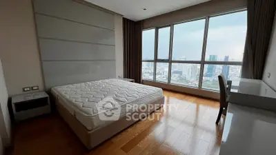 Modern bedroom with large window offering stunning city view and sleek furnishings.