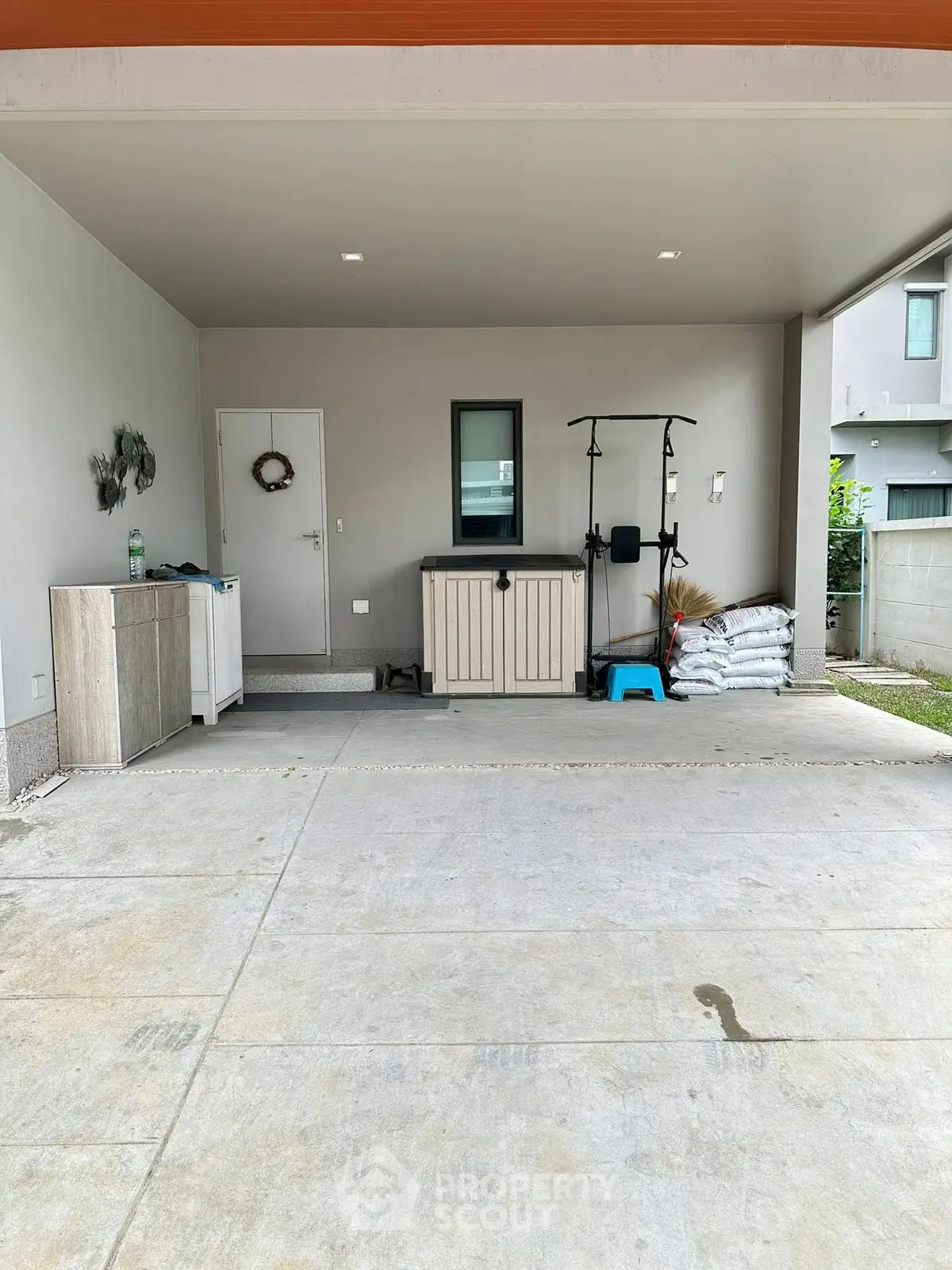 Spacious covered parking area with storage and exercise equipment