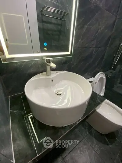 Modern bathroom with sleek sink and stylish mirror in luxury home.