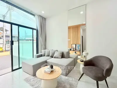 Modern living room with large glass doors and stylish furniture, offering a bright and inviting space.