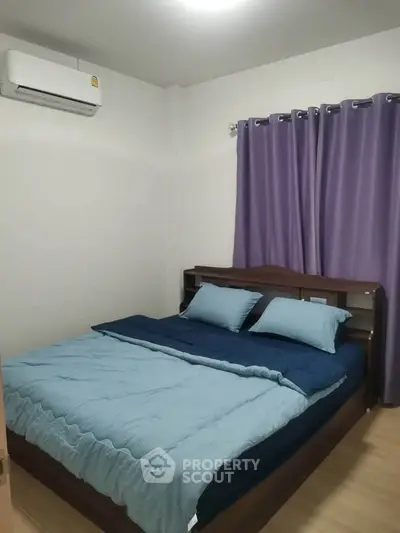 Cozy bedroom with modern air conditioning and elegant purple curtains, perfect for relaxation.