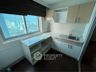 Compact kitchen with city view, featuring modern cabinetry and sleek countertops.
