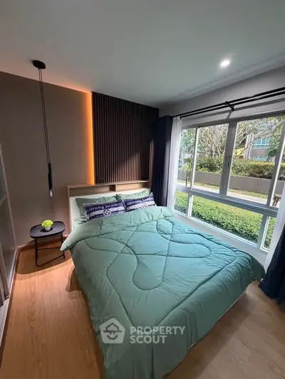 Cozy bedroom with large window and modern decor in a stylish apartment.