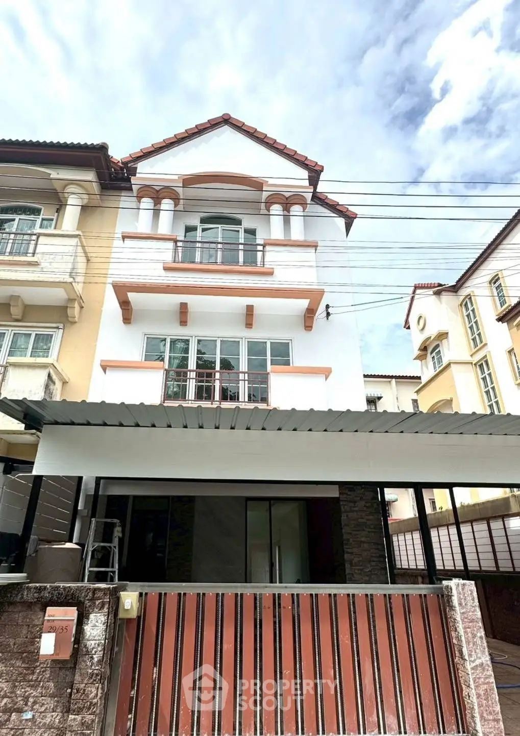 Charming multi-story townhouse with classic architecture and gated entrance in a serene neighborhood.
