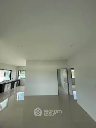 Spacious modern interior with glossy tiled floors and large windows for natural light.