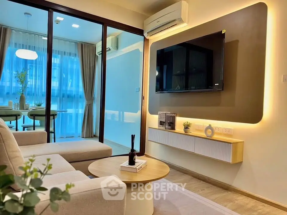 Modern living room with stylish decor and open layout, featuring a wall-mounted TV and elegant lighting.