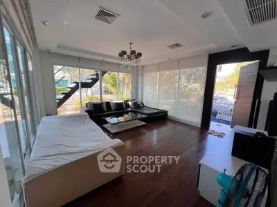 Spacious modern living room with large windows and stylish decor, perfect for relaxation and entertainment.