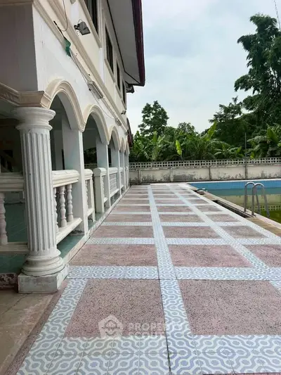 Elegant villa exterior with poolside view and classic architectural columns