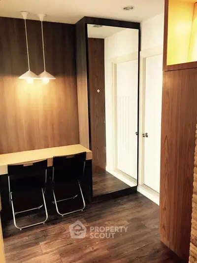 Stylish study area with modern lighting and wooden accents in a cozy apartment.