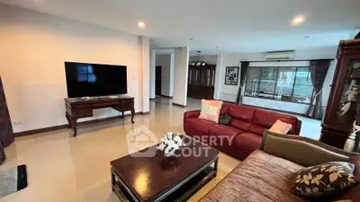 Spacious living room with modern decor and large TV, perfect for relaxation.