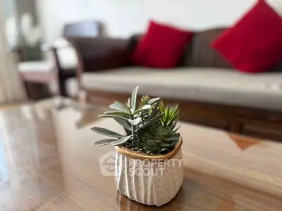 Stylish living room with modern decor and cozy seating area featuring vibrant red cushions.