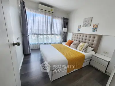 Modern bedroom with large window and stylish decor in a high-rise apartment.