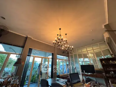 Elegant living room with chandelier and large windows overlooking garden