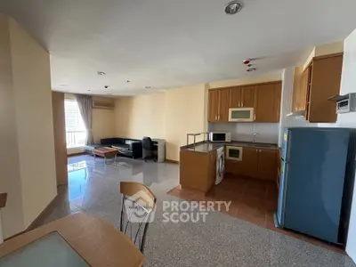 Spacious open-layout living room and kitchen with modern appliances and ample natural light.