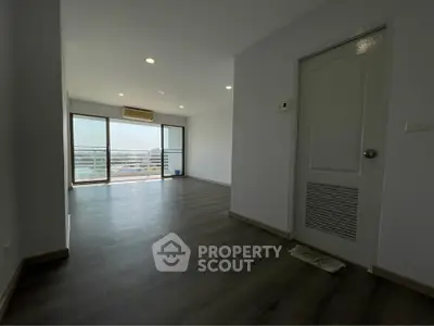 Spacious modern living room with large windows and balcony view